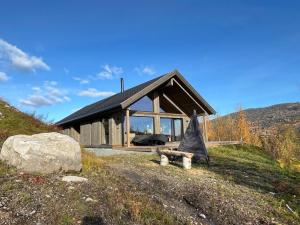 a house on a hill with a bench in front of it at Spacious lodge with sauna, ski centre in Noresund