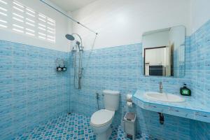 a blue tiled bathroom with a toilet and a sink at The Coastal Haven Holiday Home, Karon Beach in Karon Beach