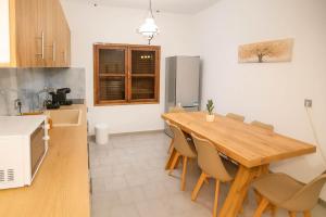 cocina con mesa de madera y sillas en Sinani Villa - Garden Oasis with Private Pool, en Kolymbia 13 fotos más