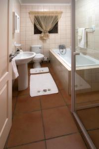 a bathroom with a sink and a toilet and a bath tub at Clarens Cottage 2 in Clarens