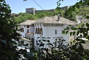 Biały dom z mężczyzną na dachu w obiekcie Old Bazaar 1790 w Gjirokastrze