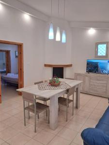 a living room with a table and a tv at Villa Noesyr in Neviano