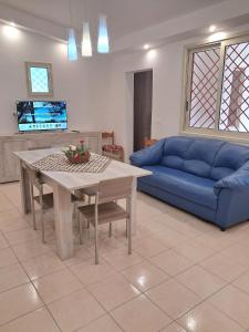 a living room with a table and a blue couch at Villa Noesyr in Neviano