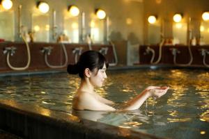 a woman sitting in a bath tub at Shigisan Kanko Hotel in Sango