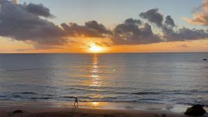 a person walking on the beach at sunset at Sardina Beach Retreat in Gáldar