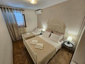 a small bedroom with two beds and a window at Room Gorana with swimming pool in Jelsa