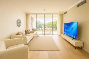un salon avec un canapé et une télévision à écran plat dans l'établissement City Beach At your door! 3BR retreat at South Bank, à Brisbane