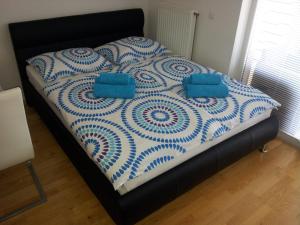 a blue and white bed with two pillows on it at Apartment Kanita in Moravske-Toplice