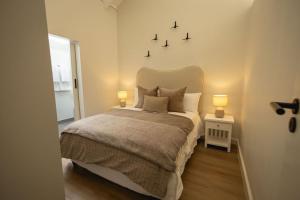 a bedroom with a bed with two lights on the wall at Two Horizons Apartment 6 in Hermanus