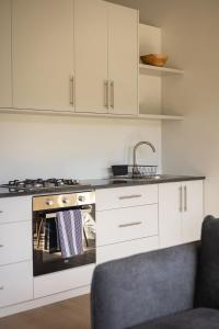 a kitchen with white cabinets and a stove top oven at Two Horizons Apartment 6 in Hermanus