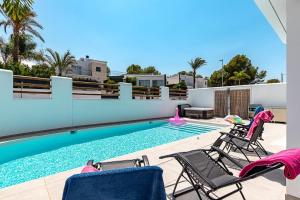 a swimming pool with two chairs and a swimming pool at Albir Albatros in Albir