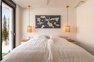 a bedroom with a large white bed with two lamps at Albir Albatros in Albir +22 photos
