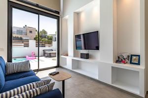 a living room with a blue couch and a tv at Albir Albatros in Albir
