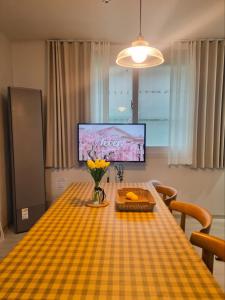 a dining room table with a yellow checkered table cloth at Ye-stay in Daegu