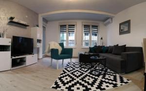 a living room with a couch and a tv at SILVER aPARTMAN 1 in Sremska Mitrovica