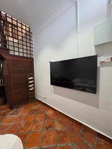 ein Wohnzimmer mit einem großen Flachbildfernseher an der Wand in der Unterkunft Popular! 4 pax Georgetown Heritage Pre-war House 2 Bedroom in George Town