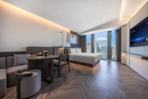 a living room with a couch and a bed and a table at Atour S Hotel Beijing Zhongguancun Institute of Technology in Beijing