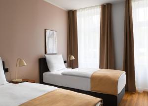 ein Hotelzimmer mit zwei Betten und einem Fenster in der Unterkunft Limehome Berlin Weserstraße, Friedrichshain in Berlin + 33 Fotos