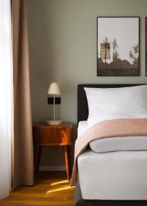 ein Schlafzimmer mit einem Bett und einem Tisch mit einer Lampe in der Unterkunft Limehome Berlin Weserstraße, Friedrichshain in Berlin