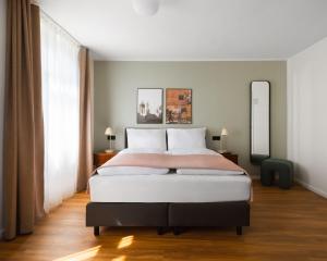 ein Schlafzimmer mit einem großen Bett und einem großen Fenster in der Unterkunft Limehome Berlin Weserstraße, Friedrichshain in Berlin