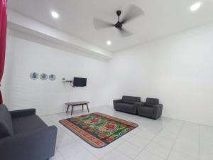 a living room with two couches and a rug at OYO Homes 90606 Casaria Cherating in Cherating