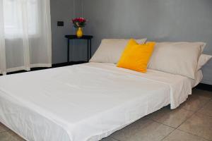 a large white bed with two yellow pillows on it at Richs Crib - Puerto Galera Affordable House in Puerto Galera