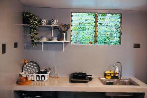 a kitchen counter with a sink and a window at Richs Crib - Puerto Galera Affordable House in Puerto Galera +13 photos