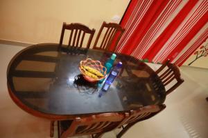 a glass table with a bowl of fruit on a chair at Shining Star in Alleppey