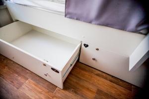 a white bunk bed with drawers and a mattress at Geography Hostel Kazan in Kazan