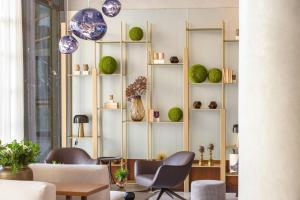 a living room with shelves with vases and chairs at Electra Palace Thessaloniki in Thessaloniki