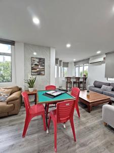 a living room with a table and red chairs at Arena Lobak Villa Retreat, Spacious Stay with Billiards, Karaoke, BBQ in Seremban