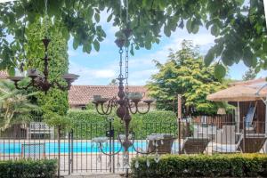 una recinzione in ferro battuto con una piscina in un cortile di L'écrin de la Rose a Yvrac-et-Malleyrand