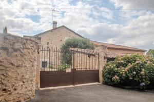 una casa con un cancello e un muro di pietra di L'écrin de la Rose a Yvrac-et-Malleyrand