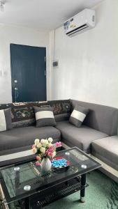 a living room with a couch and a table with flowers at Lubrin Townhouse in San Pablo