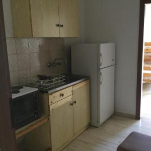 a kitchen with a white refrigerator and a stove at Thomas Apartments in Kanali