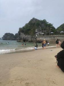 a group of people standing on a beach at Ha Thu Sea View Hotel in Cat Ba