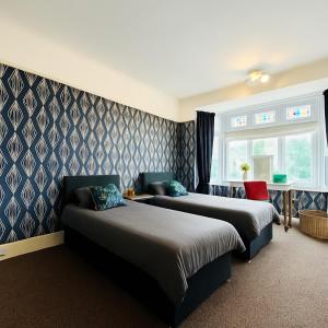 a hotel room with two beds and a window at 4 Bedroom House - Hot Tub - BBQ - Beach - Garden - Cinema - Parking in Southbourne +15 photos