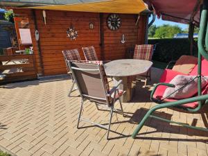 eine Terrasse mit einem Tisch und Stühlen vor einer Hütte in der Unterkunft Ferienhaus Bootsmann in Plau am See