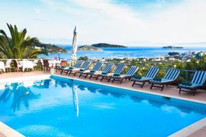 a pool with chairs and a view of the ocean at Vigles Sea View, Philian Hotels and Resorts in Skiathos Town