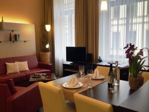 a living room with a table and a couch at Apartmenthotel Quartier M in Leipzig