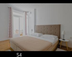 a white bedroom with a large bed and a window at Brela S1 S4-no parking in Brela
