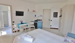 a bedroom with a bed and a table and a kitchen at Camera Molly in Cannero Riviera