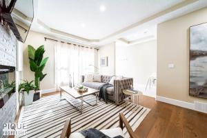 un salon avec un canapé et une table dans l'établissement Summer Haven - HotTub - FireTable - KingBed - BBQ - Sleeps8, à Edmonton