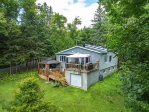 a house with a train in a yard at Absolute comfort with SPA - Le Havre du Confort in Mille-Isles