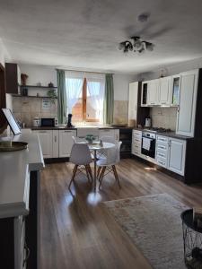 德罗贝塔-塞维林堡Casa La Balauri的配有白色橱柜、桌子和椅子的厨房