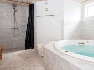 a bathroom with a bath tub and a shower at 4 star holiday home in Ringkøbing in Ringkøbing