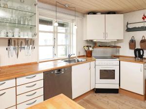 a kitchen with white cabinets and a sink at 4 star holiday home in Ringkøbing in Ringkøbing