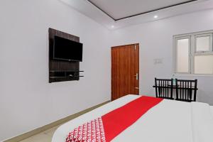 a bedroom with a bed and a flat screen tv at Hotel O A-One Inn in Bijnaur