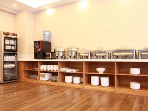 a room with wooden shelves with dishes on them at GreenTree Inn Chifeng Ningcheng County Bus Station Branch in Xihusutai