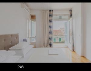 a white room with a bed and a large window at Riva Brela in Brela